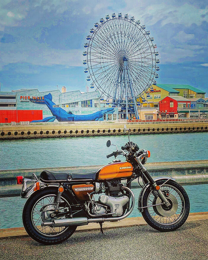 観覧車の前に立つバイク